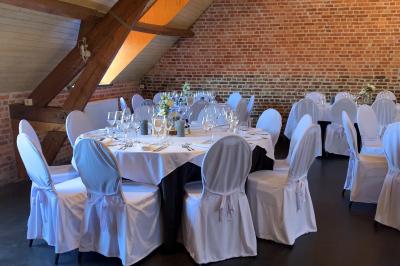 Un couple danse au centre d'une salle éclairée, entouré d'invités assis à des tables.