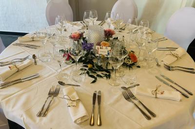 Un couple danse au centre d'une salle éclairée, entouré d'invités assis à des tables.