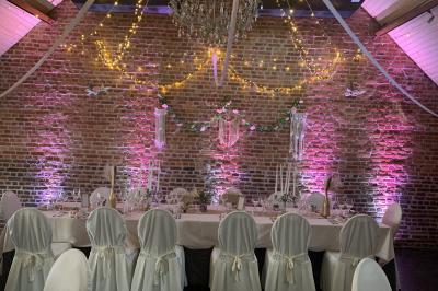 Un couple danse au centre d'une salle éclairée, entouré d'invités assis à des tables.