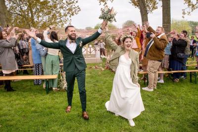 Un couple danse au centre d'une salle éclairée, entouré d'invités assis à des tables.