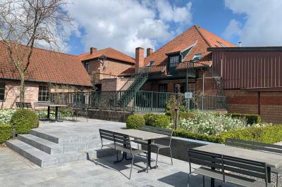 Un couple danse au centre d'une salle éclairée, entouré d'invités assis à des tables.