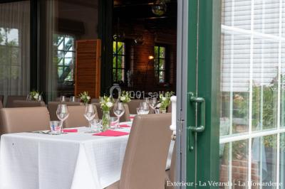 Salle de réunion avec des rangées de chaises face à un écran de projection, sous un plafond en briques apparentes.