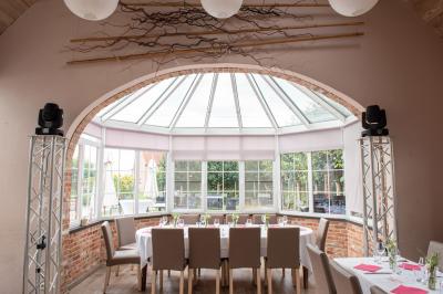Salle de réunion avec des rangées de chaises face à un écran de projection, sous un plafond en briques apparentes.