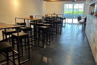 Salle de réunion avec des rangées de chaises face à un écran de projection, sous un plafond en briques apparentes.