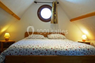 Tente rouge et blanche abritant des tables dressées avec nappes et décorations pour un repas en extérieur.