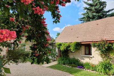 Tente rouge et blanche abritant des tables dressées avec nappes et décorations pour un repas en extérieur.