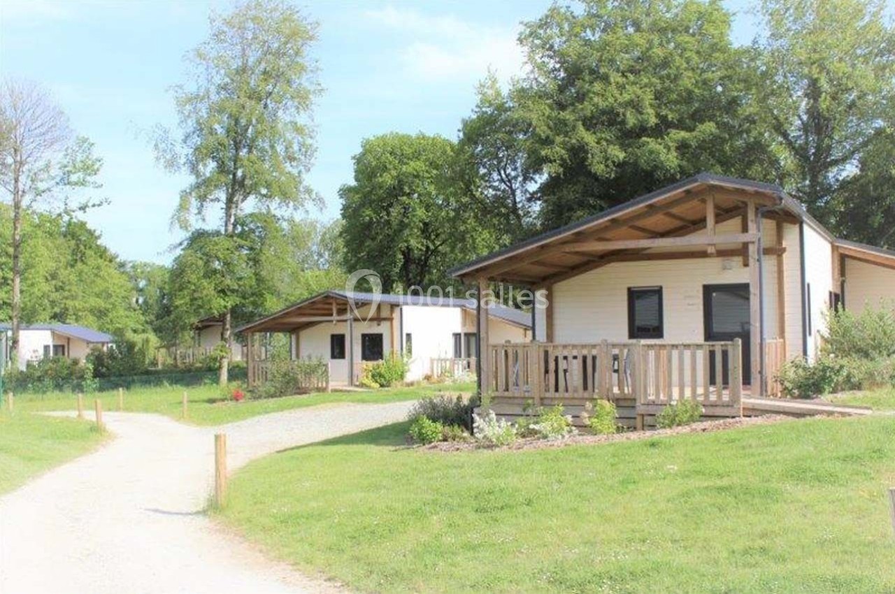 Location salle Merdrignac (Côtes-d'Armor) - Val de Landrouet #14 Chalets en bois avec terrasses, entourés de pelouses et d'arbres, dans un cadre naturel et ensoleillé.
