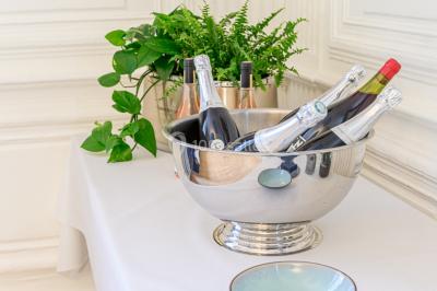 Plantes d'intérieur variées dans des pots en verre et en métal doré, disposées sur une cheminée en marbre noir.