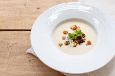 Plantes d'intérieur variées dans des pots en verre et en métal doré, disposées sur une cheminée en marbre noir.