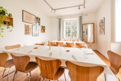 Plantes d'intérieur variées dans des pots en verre et en métal doré, disposées sur une cheminée en marbre noir.