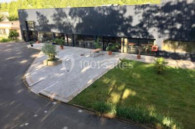 Salle de réception moderne avec tables hautes colorées, buffet en arrière-plan et éclairage suspendu.