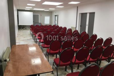 Salle de réception moderne avec tables hautes colorées, buffet en arrière-plan et éclairage suspendu.