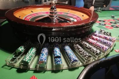 Salle de réception moderne avec tables hautes colorées, buffet en arrière-plan et éclairage suspendu.