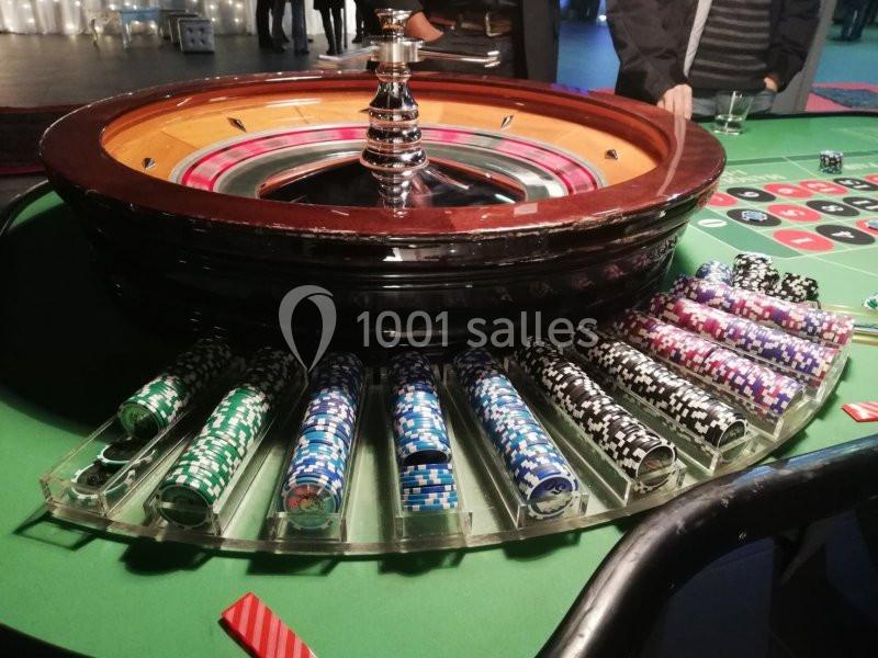 Roulette de casino avec des jetons colorés alignés sur le bord d'une table de jeu verte.