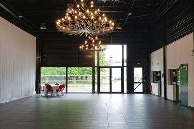 Salle de réception moderne avec tables hautes colorées, buffet en arrière-plan et éclairage suspendu.