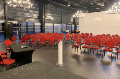 Comptoir lumineux multicolore dans un espace intérieur sombre avec des panneaux ’vestiaire’ en arrière-plan.