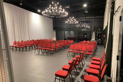 Comptoir lumineux multicolore dans un espace intérieur sombre avec des panneaux ’vestiaire’ en arrière-plan.