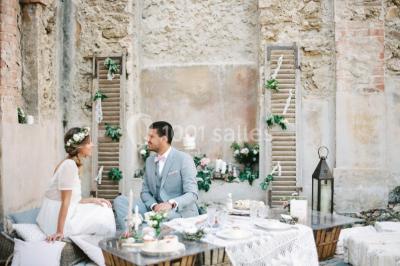 Vue aérienne d'une grande maison de style provençal avec des tables dressées pour un événement en extérieur.