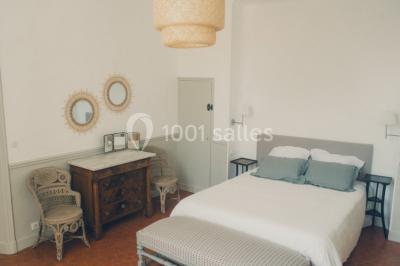 Vue aérienne d'une grande maison de style provençal avec des tables dressées pour un événement en extérieur.