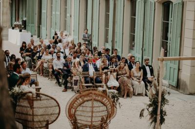 Vue aérienne d'une grande maison de style provençal avec des tables dressées pour un événement en extérieur.