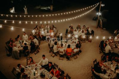 Vue aérienne d'une grande maison de style provençal avec des tables dressées pour un événement en extérieur.