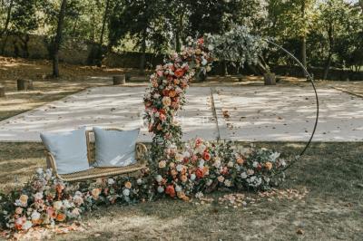 Vue aérienne d'une grande maison de style provençal avec des tables dressées pour un événement en extérieur.