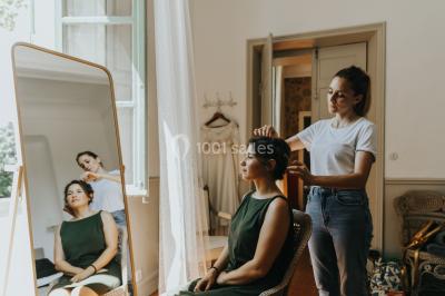 Vue aérienne d'une grande maison de style provençal avec des tables dressées pour un événement en extérieur.