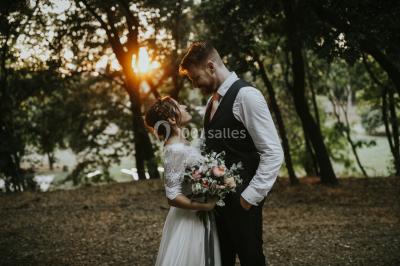 Vue aérienne d'une grande maison de style provençal avec des tables dressées pour un événement en extérieur.