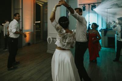 Vue aérienne d'une grande maison de style provençal avec des tables dressées pour un événement en extérieur.