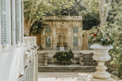 Vue aérienne d'une grande maison de style provençal avec des tables dressées pour un événement en extérieur.