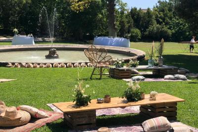 Vue aérienne d'une grande maison de style provençal avec des tables dressées pour un événement en extérieur.