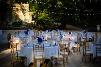 Vue aérienne d'une grande maison de style provençal avec des tables dressées pour un événement en extérieur.