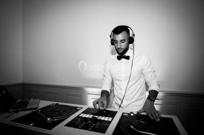 Vue aérienne d'une grande maison de style provençal avec des tables dressées pour un événement en extérieur.