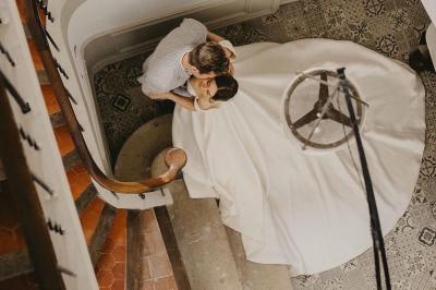 Vue aérienne d'une grande maison de style provençal avec des tables dressées pour un événement en extérieur.