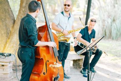 Vue aérienne d'une grande maison de style provençal avec des tables dressées pour un événement en extérieur.
