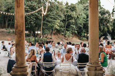 Vue aérienne d'une grande maison de style provençal avec des tables dressées pour un événement en extérieur.