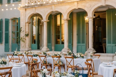 Miniature Location salle Marseille 14 (Bouches-du-Rhône) - Bastide de Toursainte #95 Chaises transparentes disposées en rangées sur une allée blanche, entourées d'arbres dans un cadre extérieur.