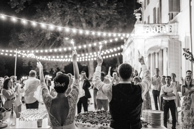 Miniature Location salle Marseille 14 (Bouches-du-Rhône) - Bastide de Toursainte #96 Chaises transparentes disposées en rangées sur une allée blanche, entourées d'arbres dans un cadre extérieur.