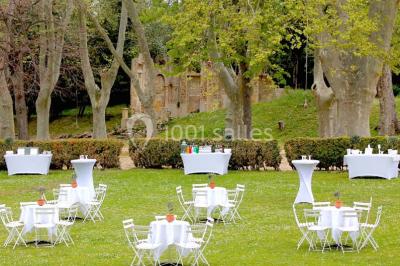 Vue aérienne d'une grande maison de style provençal avec des tables dressées pour un événement en extérieur.