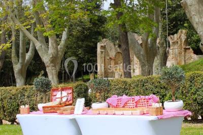Vue aérienne d'une grande maison de style provençal avec des tables dressées pour un événement en extérieur.