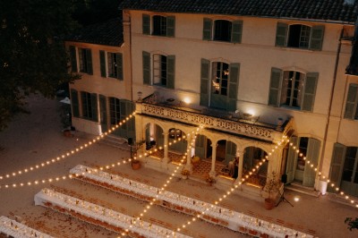 Miniature Location salle Marseille (Bouches-du-Rhône) - Bastide De Toursainte #24 Écran de projection en plein air installé dans un parc, entouré de chaises blanches et de quelques personnes.