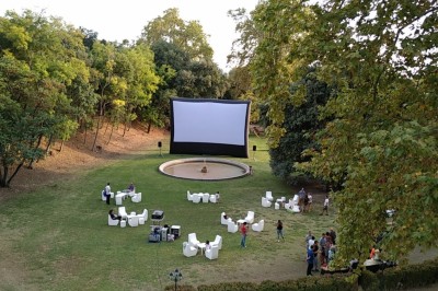 Miniature Location salle Marseille (Bouches-du-Rhône) - Bastide De Toursainte #30 Écran de projection en plein air installé dans un parc, entouré de chaises blanches et de quelques personnes.