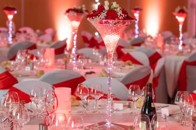 Vue d'une prairie verdoyante avec un grand arbre à gauche et des bâtiments ruraux sous un ciel dégagé.