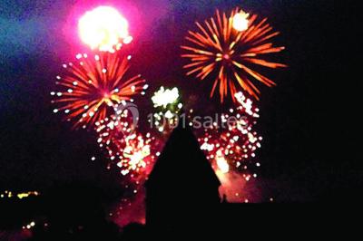 Deux voitures à pédales rétro sur un tapis rouge devant une tente tipi et un tableau noir dans un jardin.
