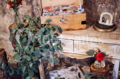 Deux voitures à pédales rétro sur un tapis rouge devant une tente tipi et un tableau noir dans un jardin.