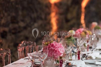 Deux voitures à pédales rétro sur un tapis rouge devant une tente tipi et un tableau noir dans un jardin.