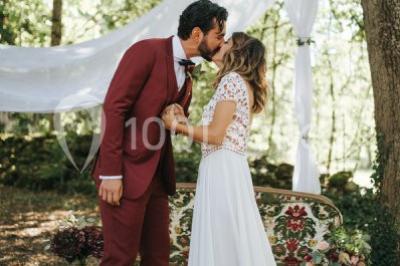 Deux voitures à pédales rétro sur un tapis rouge devant une tente tipi et un tableau noir dans un jardin.