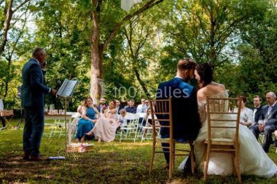 Deux voitures à pédales rétro sur un tapis rouge devant une tente tipi et un tableau noir dans un jardin.