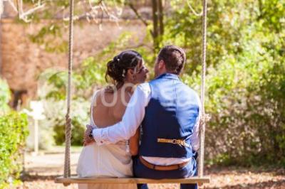 Deux voitures à pédales rétro sur un tapis rouge devant une tente tipi et un tableau noir dans un jardin.