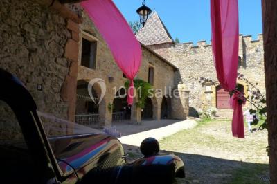 Deux voitures à pédales rétro sur un tapis rouge devant une tente tipi et un tableau noir dans un jardin.